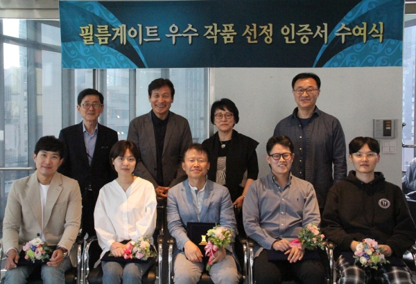 제16회 필름게이트 우수작품 선정작가(앞줄 왼쪽부터 양재준, 신서영, 전승표 부, 김동욱, 양인철)와안성기 이사장(뒷줄 가운데) 및 재단 임원(김두호, 채윤희, 박종원 이사)]