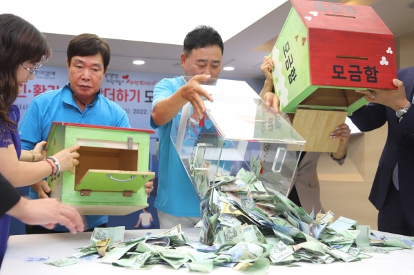 사랑의열매 회관에서 열린 제20회 사랑더하기 모금함 전달식에서 개그맨 황기순 씨 등 관계자들이 모금함을 열고 현장 모금 기부금을 세고 있다.