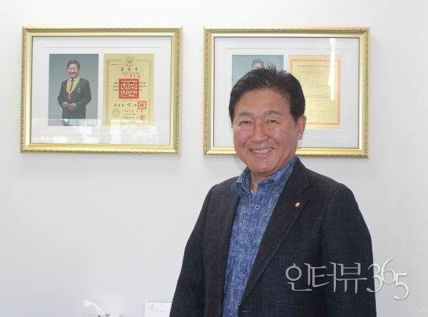 박종범 영산그룹 회장이 지난 16일 서울 양재동 영산그룹 서울 법인 사무실에서 인터뷰365와 인터뷰를 마치고 2013년 수훈한 국민훈장 모란장(왼쪽)과 오스트리아 정부가 주는 금장 훈장을 배경으로 포즈를 취했다./사진=박현수&nbsp;