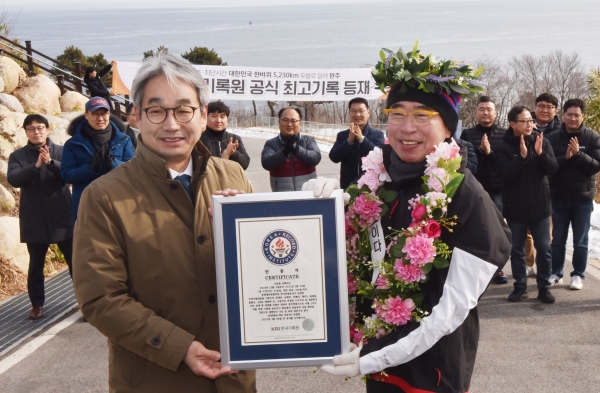 대한민국 국토경계 한바퀴 국내 최단시간 기록을 한국기록원으로부터 기록 인증서를 전달받는 사진 선양소주 조웅래 회장(우), 한국기록원 김덕은 한국기록원장(왼)