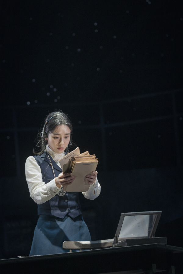 국립극단 '사일런트 스카이' 공연사진. 사진건판의 변광성들이 보여주는 밝기와 거리, 맥동의 패턴을 찾기 위해 수많은 시간과 노력을 들인 '헨리에타 레빗(안은진)'은 상관관계를 도출하지 못해 깊은 고뇌에 빠진다.