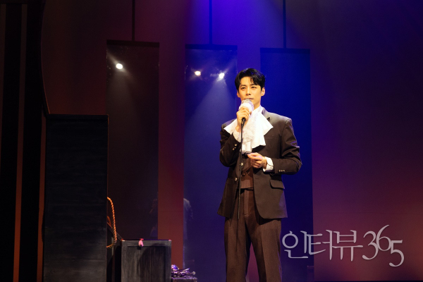 음악극 '노베첸토' 공연 사진. 마이크를 든 배우는 '선상 MC(주민진)'로 변화해 미국과 유럽을 오가는 여객선 버지니아 호를 움직이는 선장과 선원, 의사, 요리사, 밴드를 소개한다.