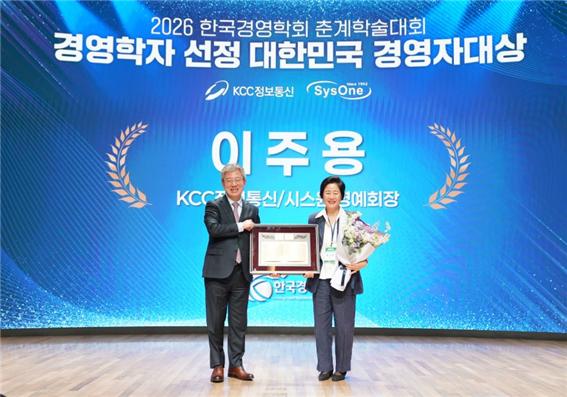 지난 15일 서울 대한상공회의소 국제회의장에서 열린 '2026 한국경영학회 춘계학술대회'에서 수상자인 이주용 KCC정보통신·시스원 명예회장을 대신해 부인 최기주 여사(오른쪽)가 한국경영학회 최정일 회장으로부터 상을 받고 기념촬영을 하고 있다./사진=KCC정보통신 제공
