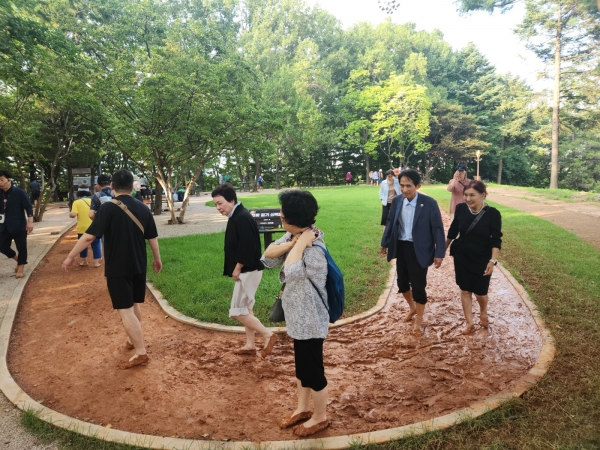 19일 포럼 뒤 맨발걷기국민운동본부 회원들이 국회 내 조성된 황톳길에서 맨발걷기를 하고 있다./사진=신향식